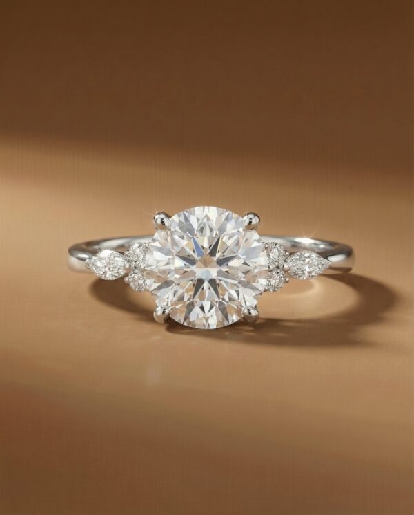 แหวนหมั้นเพชรกลมเม็ดกลาง ตัวเรือนทองคำขาว ประดับเพชรมาคีส์บ่าข้าง จาก Kos