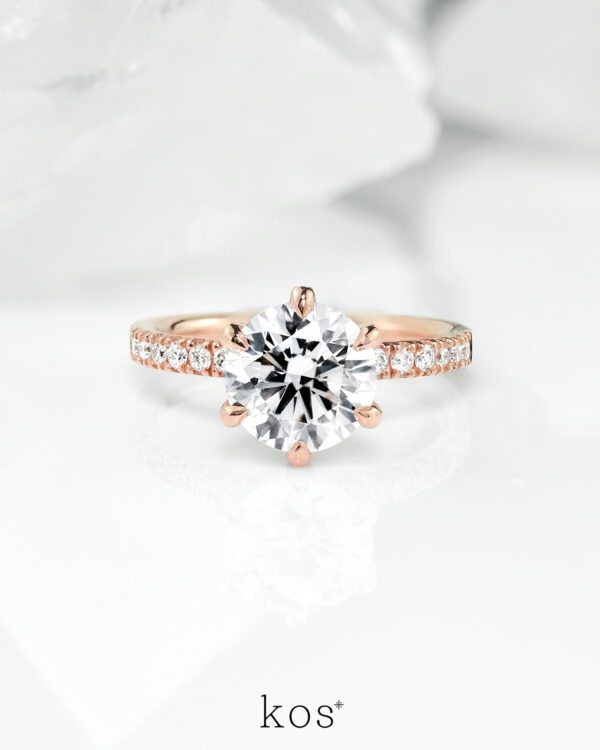 แหวนหมั้นเพชรทรงกลม Bellezza บนตัวเรือน Rose Gold ประดับเพชร Pavé มองจากด้านข้าง เน้นความหรูหราและประกายเพชร