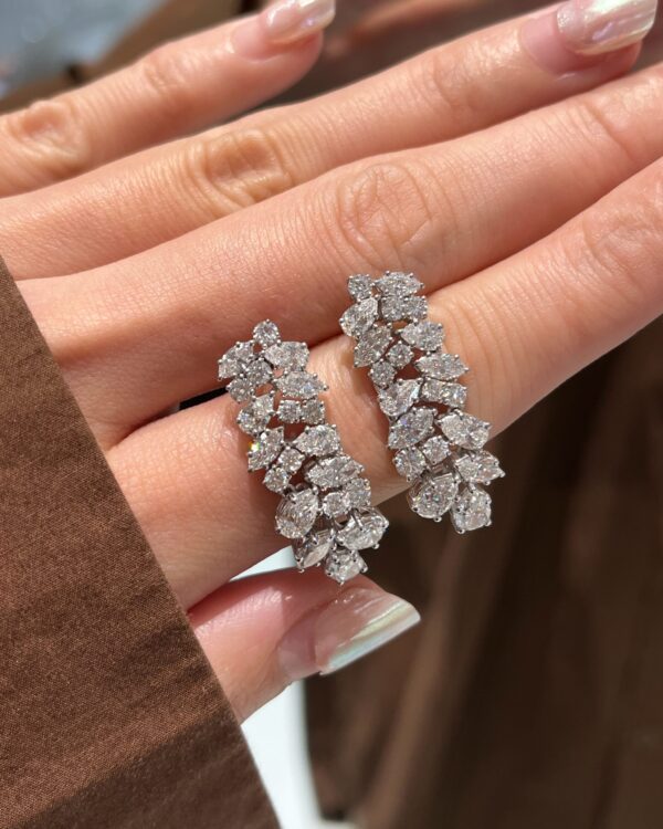 ต่างหูเพชรระย้าดีไซน์ช่อเพชรจาก Kos ประกอบด้วยเพชรทรงหยดน้ำและทรงกลมหลายเม็ดบนตัวเรือนสีขาว สำหรับใส่ออกงานหรู