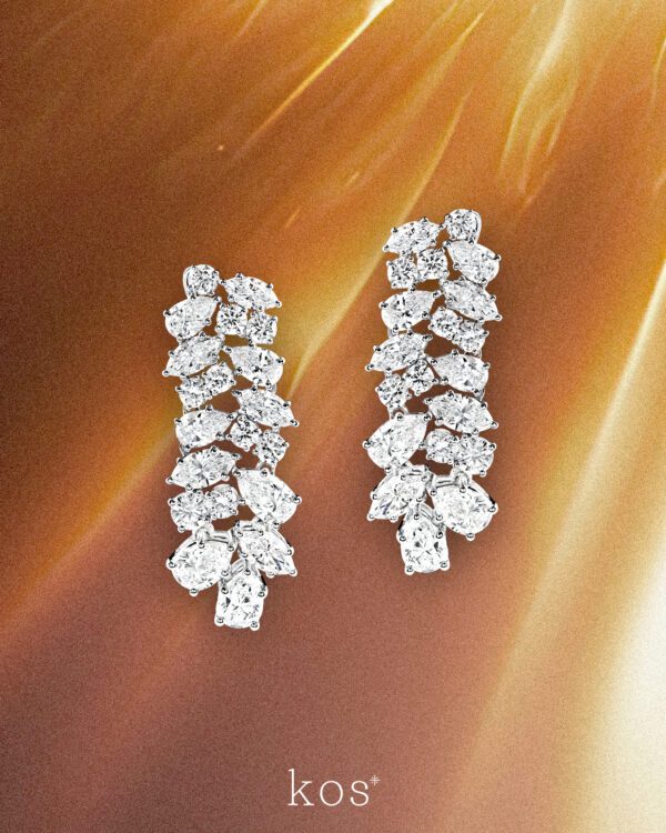 ต่างหูเพชรระย้าดีไซน์ช่อเพชรจาก Kos ประกอบด้วยเพชรทรงหยดน้ำและทรงกลมหลายเม็ดบนตัวเรือนสีขาว สำหรับใส่ออกงานหรู